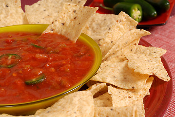 Image showing A closeup of a bowl of salsa with tortilla chips and jalapeno pe