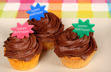 Image showing Closeup of three chocolate frosted cupcakes with 