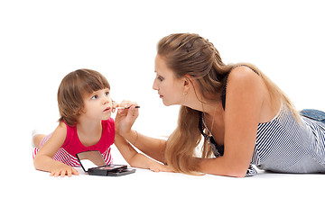 Image showing Young mother paints lipstick little daughter in the studio