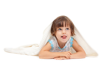 Image showing Little girl lying on the floor wrapped in a light blanket and to