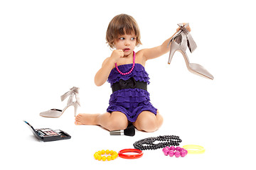 Image showing Cute little girl with cosmetics and women's shoes in the studio