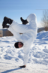 Image showing Soldier in white camouflage makes a break dance