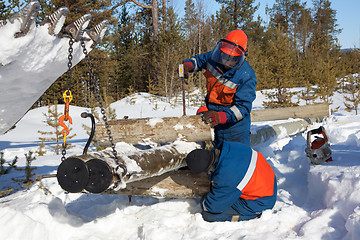 Image showing Installers collect a power pole in the snow