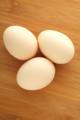 Image showing Three eggs on wooden background