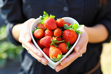 Image showing strawberry in heart shape bowl with hand