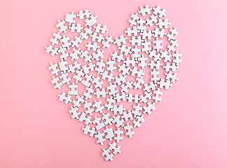 Image showing puzzle made heart sharp on pink background