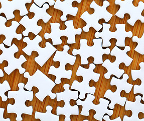 Image showing white jigsaw puzzle on wooden background