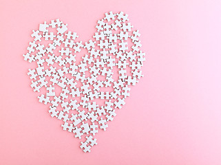 Image showing puzzle made heart sharp on pink background