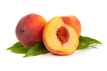 Image showing Three tasty juicy peaches with a half  on a white background