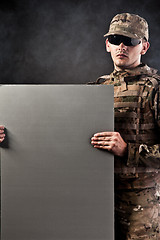 Image showing Modern soldier is holding a poster