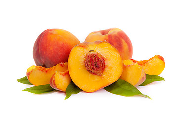 Image showing Three tasty juicy peaches with a half and slices  on a white bac