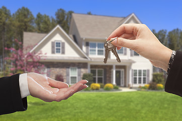 Image showing Agent Handing Over the House Keys in Front of New Home