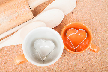 Image showing Ceramic cups with cookies cutter on cooking table