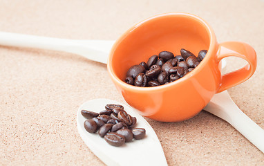 Image showing Coffee bean in ceramic cup and wood spoon 