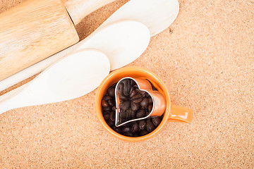 Image showing Cup of coffee bean and cookies cutter in kitchen 