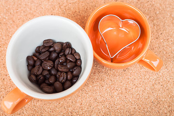 Image showing Cup of coffee bean and cookies cutter on cork background