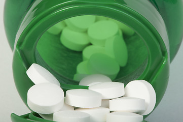 Image showing White pills and a container