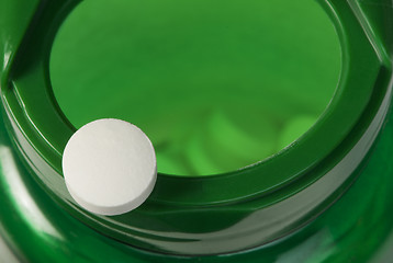 Image showing White pills and a container