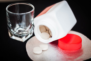 Image showing Open pill bottle with brown medicine spilling out  