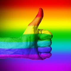 Image showing Image of a mans hand showing thumb up, rainbow flag