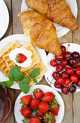 Image showing Tasty breakfast - tea, croissants, wafers and fruits