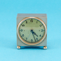 Image showing grunge metallic retro clock stand blue background 