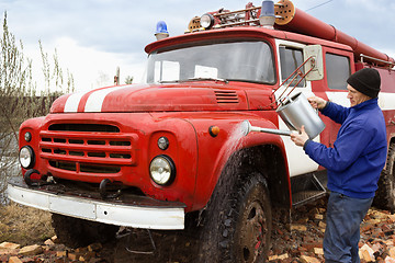 Image showing The driver washes the old  fire truck