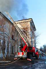 Image showing Firefighters extinguish a burning palace of culture