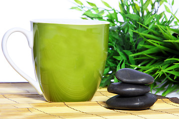 Image showing Green mug and spa massage stones