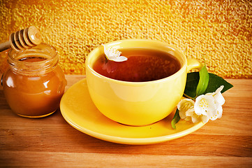 Image showing Cup of tea with a flower of a jasmin and honey