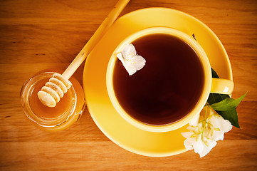 Image showing The top view on a cup of tea with a flower of a jasmin and honey