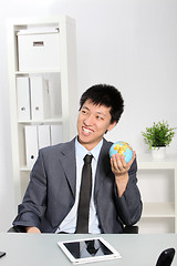 Image showing Asian Businessman Holding Small Globe