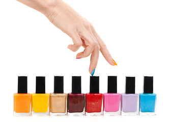 Image showing Female hand fingers are the colored paints polish on a white bac