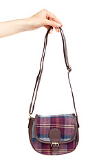 Image showing fashionable plaid handbag in female hand.