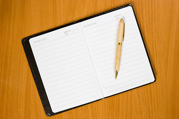 Image showing Notebook and pen on the  wooden table