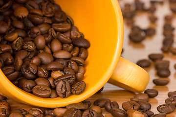 Image showing Yellow cup with many coffee beans