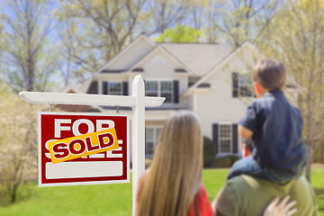 Image showing Family Facing Sold For Sale Real Estate Sign and House