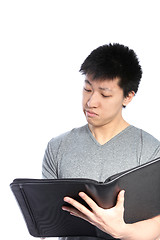 Image showing Casual Asian Man Looking Inside Binder