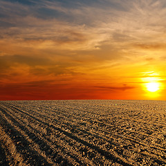 Image showing red sunset over ploughed farm field