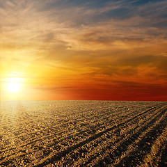 Image showing red sunset over ploughed farm field