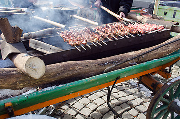 Image showing man hand fork bake pork meat fire outdoor food 