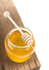 Image showing Honey in bank on wooden boards