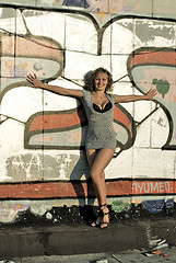 Image showing Attractive young woman against a wall of graffiti