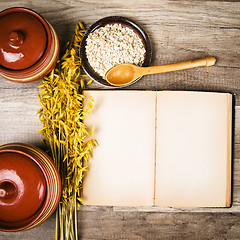 Image showing The top view on the opened cookbook and kitchen utensils