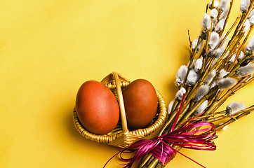 Image showing bunch of willow branches and two Easter eggs in basket 