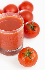 Image showing Glass of tomato juice and tomatoes