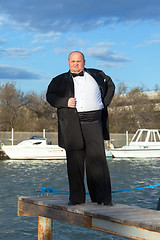 Image showing Fat man in tuxedo on pier