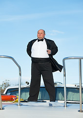 Image showing Fat man in tuxedo with glass wine