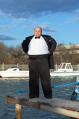 Image showing Fat man in tuxedo on pier