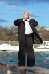 Image showing Fat man in tuxedo on pier